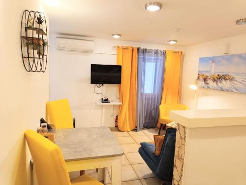 a living room with a table and yellow chairs at AS Lucana Apartment - Ground floor in Vis