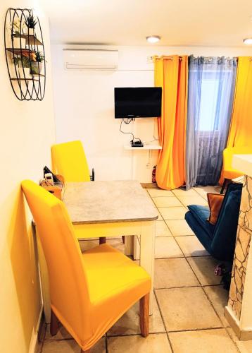 a dining room with a table and yellow chairs at AS Lucana Apartment - Ground floor in Vis