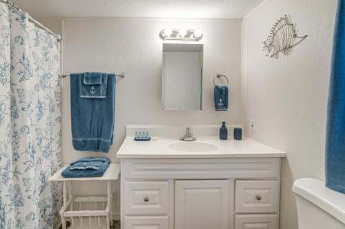 a bathroom with a sink and a blue shower curtain at Bring Your Boat! Homosassa Retreat Less Than 5 Mi to River in Homosassa Springs