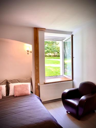 a bedroom with a bed and a window with a chair at Kino na łące apartament z jacuzzi i prywatną salą kinową in Wojcieszyce
