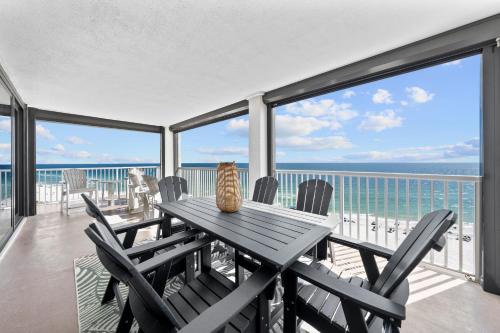 een tafel en stoelen op een balkon met uitzicht op de oceaan bij Sunrise Serinity Summer House 1101A in Orange Beach