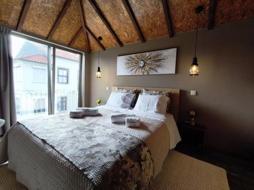 een slaapkamer met een groot bed en een groot raam bij Refúgio da Nau in Vila do Conde