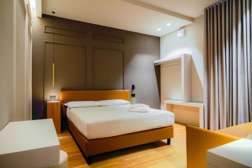 a small bedroom with a bed and a table at Virginia Madre Boutique Guest House in San Benedetto del Tronto