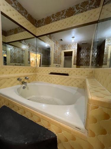a bathroom with a large tub with a mirror at The Jefferson Suite in Eagle Pass
