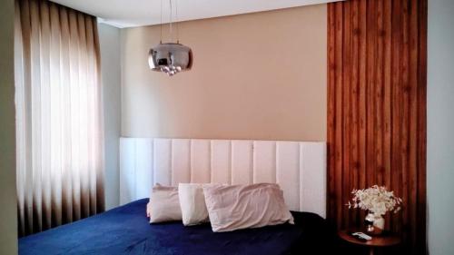 um quarto com uma cama com lençóis azuis e uma janela em Sejam bem vindos, ao paraíso de Genipabu! em Genipabu