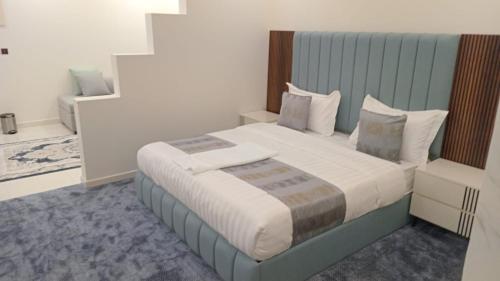 a bedroom with a large bed with a blue headboard at فيلمست ريزدنس ابها للشقق الفندقية Velmist Residence Abha in Abha