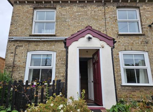 a brick house with a red and white door at B&B Rooms in terraced house in Sudbury centre in Sudbury