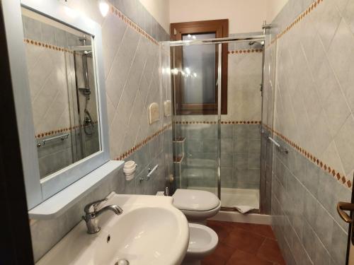une salle de bains avec lavabo, toilettes et douche dans l'établissement Villetta Sunrise 21, à Costa Rei