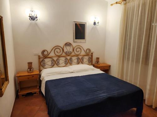 une chambre avec un grand lit et deux tables de nuit dans l'établissement Villetta Sunrise 21, à Costa Rei