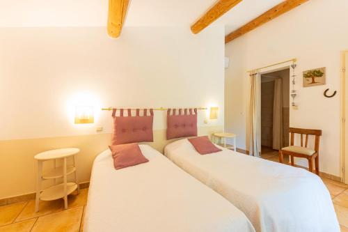 a bedroom with two beds and two chairs at Le Mas Du Loup in Moustiers-Sainte-Marie