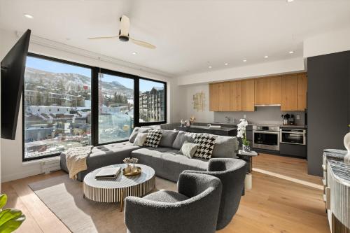 een woonkamer met een bank en stoelen en een keuken bij Modern 2 Bedroom Ski In&Out Condo 05 in Snowmass Village
