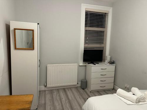 a bedroom with a bed and a television on a dresser at The good rest in London