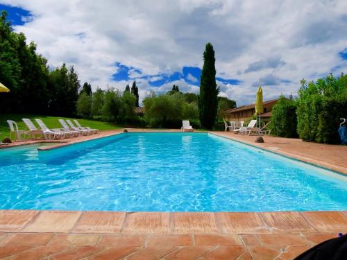 a large swimming pool with blue water and chairs at 2 Br,1bath with 2 AC units, garden apt in Chianti! in La Collina