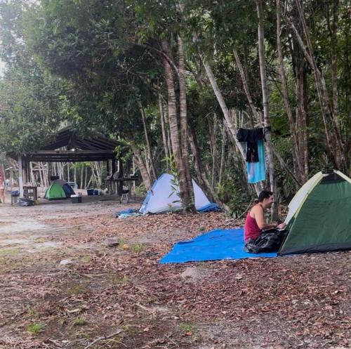 プレジデンテ・フィゲイレドにあるParaíso Manancialのテント横の毛布の上に座っている女性