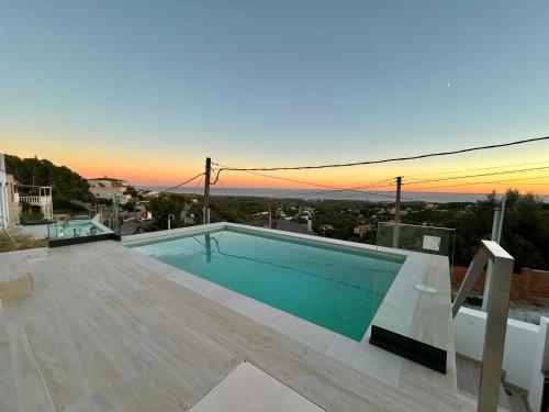 a swimming pool on the roof of a house at Les Flors de Cunit Villa Edelweiss in Cunit