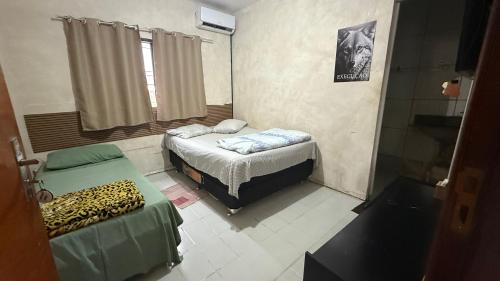 a small room with a bed and a window at Minas Hotel Uberlândia in Uberlândia