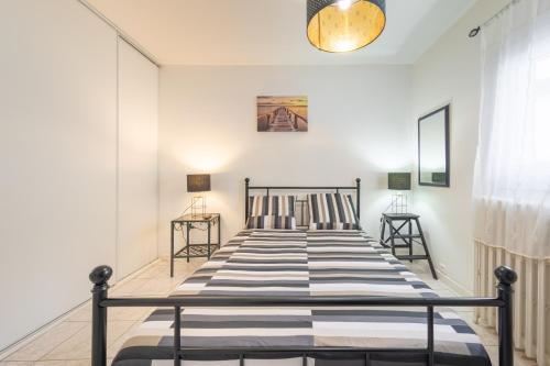 a bedroom with a bed and two side tables at Chambre calme, zen & lumineuse in Sevran