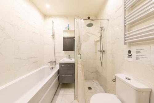 a bathroom with a tub and a toilet and a sink at Chambre calme, zen & lumineuse in Sevran