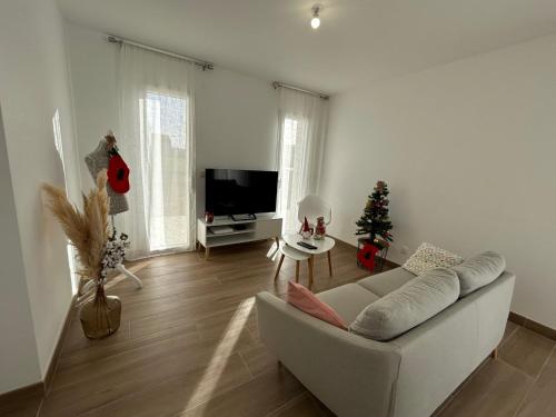 Sala de estar con sofá blanco y árbol de Navidad en Pavillon "Le Mexico" - 8 min Futuroscope, en Saint-Georges-lès-Baillargeaux