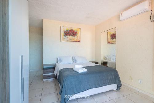 ItajubáにあるCasas completas em condomínio com piscina a 110m do Mar - ONIsのベッドのある寝室と洗面台のある浴室