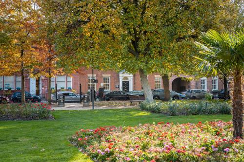 a park with flowers in front of a building at 10 Park Square East, Luxury Serviced Apartments in Leeds
