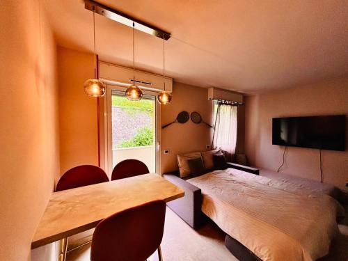 a room with a bed and a table and chairs at Monte Carlo Vista in Beausoleil