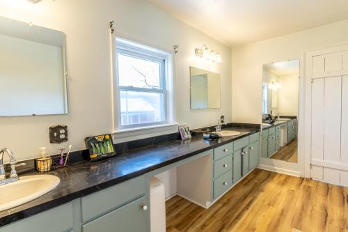 ein Badezimmer mit zwei Waschbecken und einem großen Spiegel in der Unterkunft Charming Farmhouse w King Bed Hot Tub & EV Charger 