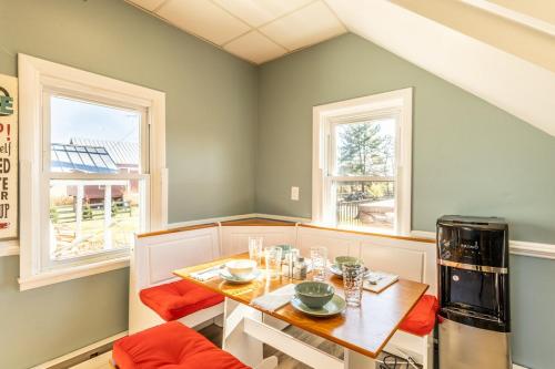 ein Esszimmer mit einem Tisch und zwei Fenstern in der Unterkunft Charming Farmhouse w King Bed Hot Tub & EV Charger 
