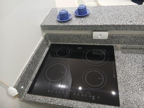 クルーズ・ダス・アルマスにあるFlat Centralのカウンターの上に青い食器が置かれたコンロのオーブン