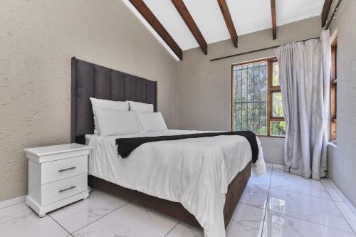 ein Schlafzimmer mit großem Bett und Fenster in der Unterkunft Villa Picasso - 3 Bed Villa in Johannesburg