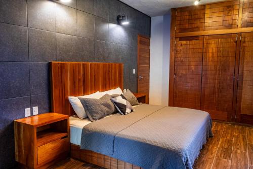 a bedroom with a bed with a wooden headboard at Casa NAJ BALAM in Bacalar