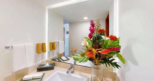 a bathroom with a sink and a vase of flowers at Park Royal Beach Acapulco - All Inclusive in Acapulco