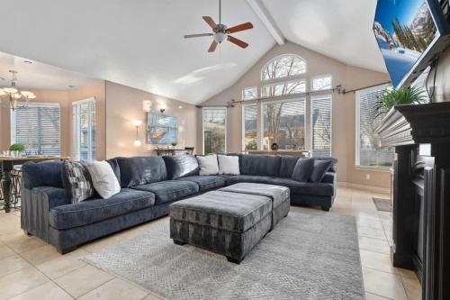 a living room with a blue couch and a table at Riviera Retreat in Salt Lake with Private Hot Tub and Theater in Millcreek