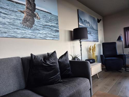a living room with a couch and a bird flying in the air at Villa Walter Lofoten with SAUNA in Kvalnes
