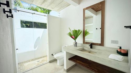 a bathroom with a sink and a toilet and a mirror at Senda Beach House Tayrona in Buritaca