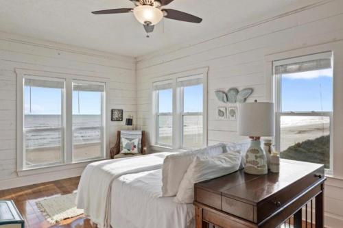 a bedroom with a bed and a table with a lamp at Paradise Beachfront Firepit Couples Retreat in Caplen