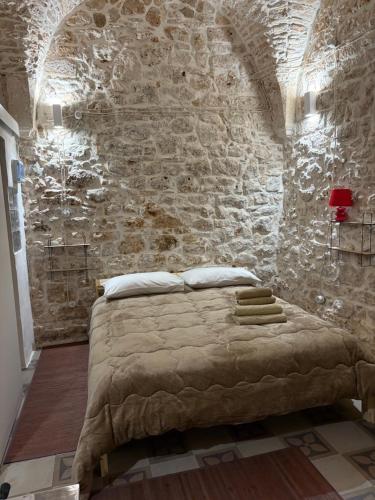 une chambre avec un lit dans un mur de pierre dans l'établissement Liuzzi, à Martina Franca