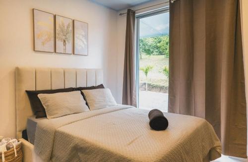 a bedroom with a bed and a large window at 3-bedroom The Dream House - Herradura & Los Sueños Getaway in Herradura