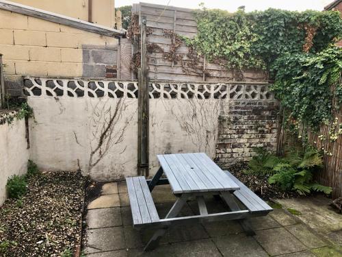 una mesa de picnic sentada frente a una pared en Trendy Terrace, en Bristol