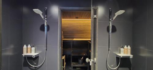 a bathroom with a shower and a sink and a mirror at Riverside villa with sauna and jacuzzi in Rovaniemi