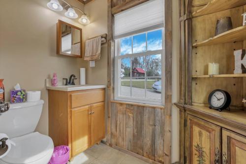 a bathroom with a toilet and a window at Cabin with Character in New Lexington