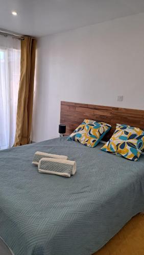 a bedroom with a large bed with two pillows at La Kaz Héliconias in Le Tampon