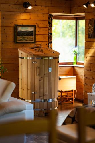 a wooden cabin with a hot tub in a room at Abies Alba By Pinus Villas in Yarema residence zone