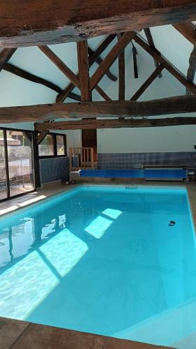 a large blue swimming pool in a building at Les 2 Ginkgos à 5 minutes de Beauval in Seigy