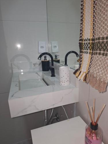 a bathroom with a sink and a mirror at Casa Familiar 2 quartos em Búzios in Búzios