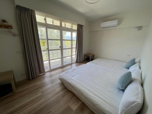 a bedroom with a bed and a large window at Dongzi Dongzi Wellness B&B in Wujie