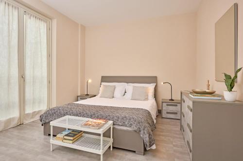 um quarto branco com uma cama e uma mesa em Tra la Rocca e il Lago em Angera