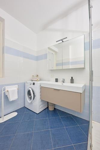 a bathroom with a washing machine and a sink at Tra la Rocca e il Lago in Angera