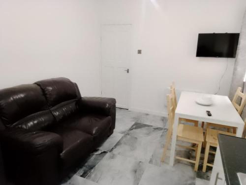 a living room with a brown leather couch and a table at Modern 2 bedrooms Apartment- Ashton-Under-Lyne- Hosts 5 persons in Ashton under Lyne