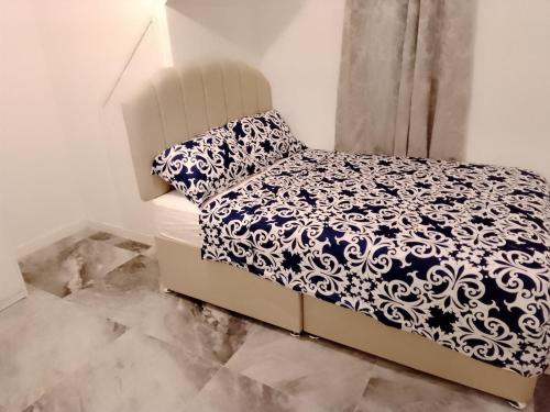 a small bedroom with a bed with a pillow and a window at Modern 2 bedrooms Apartment- Ashton-Under-Lyne- Hosts 5 persons in Ashton under Lyne